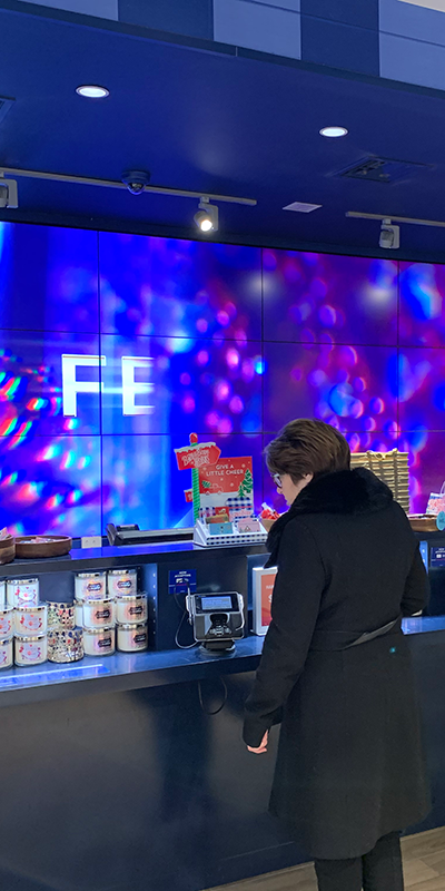 Person standing at a counter examining the candles and other products.