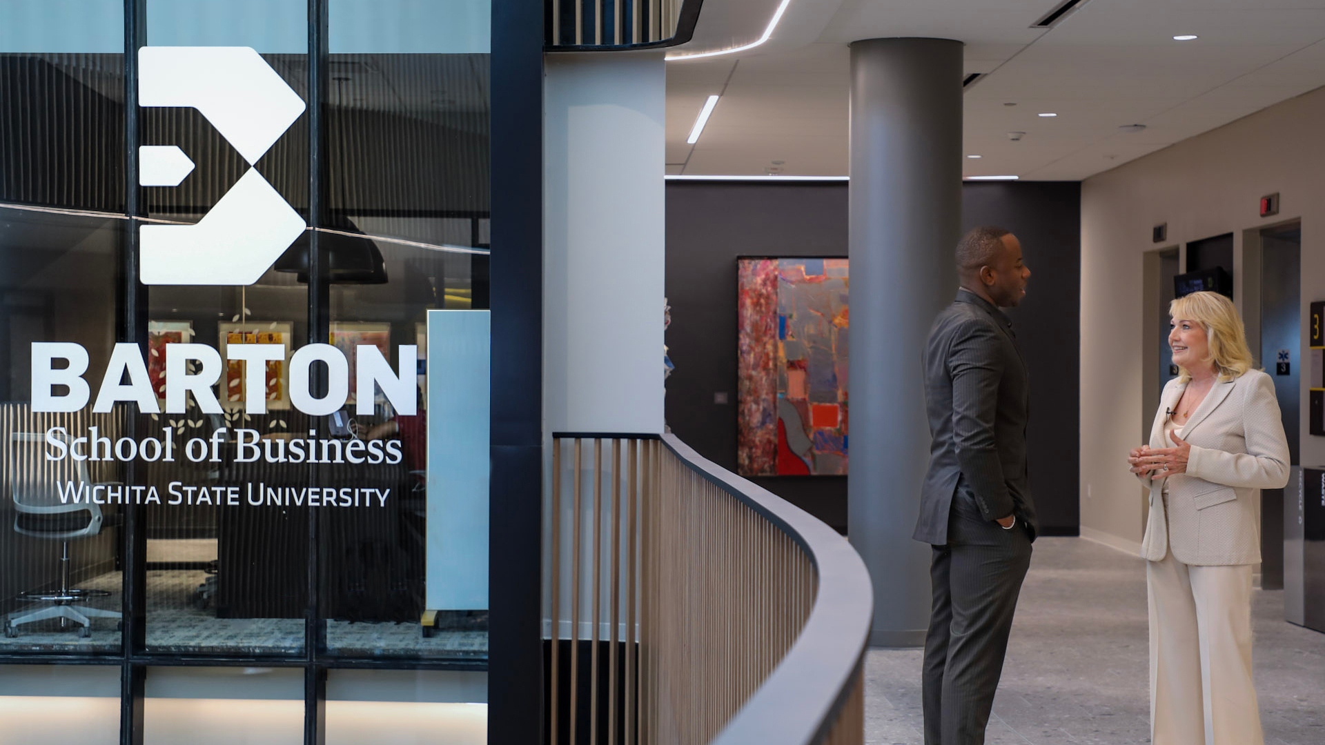 Top woman CEO speaks with male grad student in Woolsey Hall, home of the Barton School of Business.