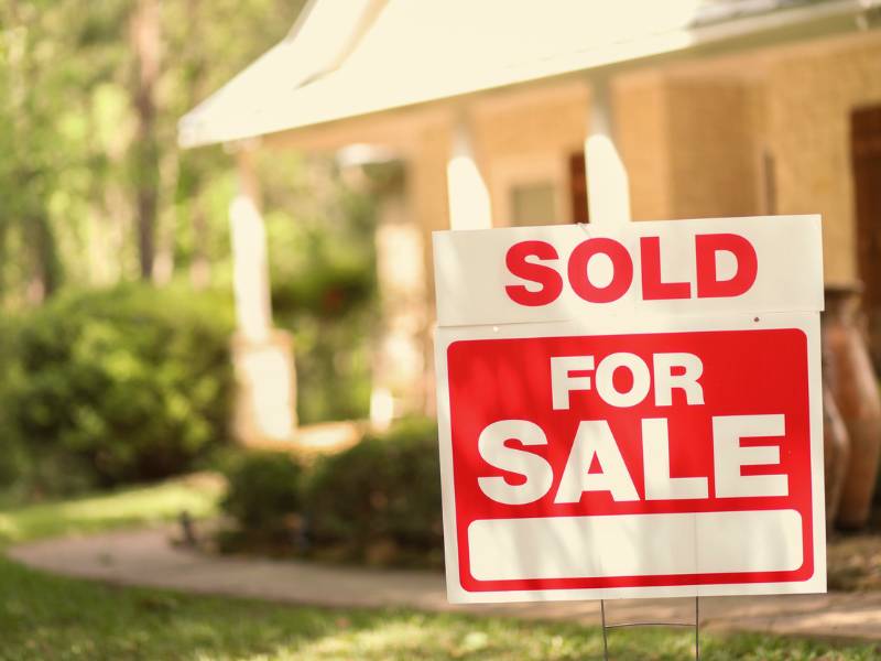 For sale sign in front of house