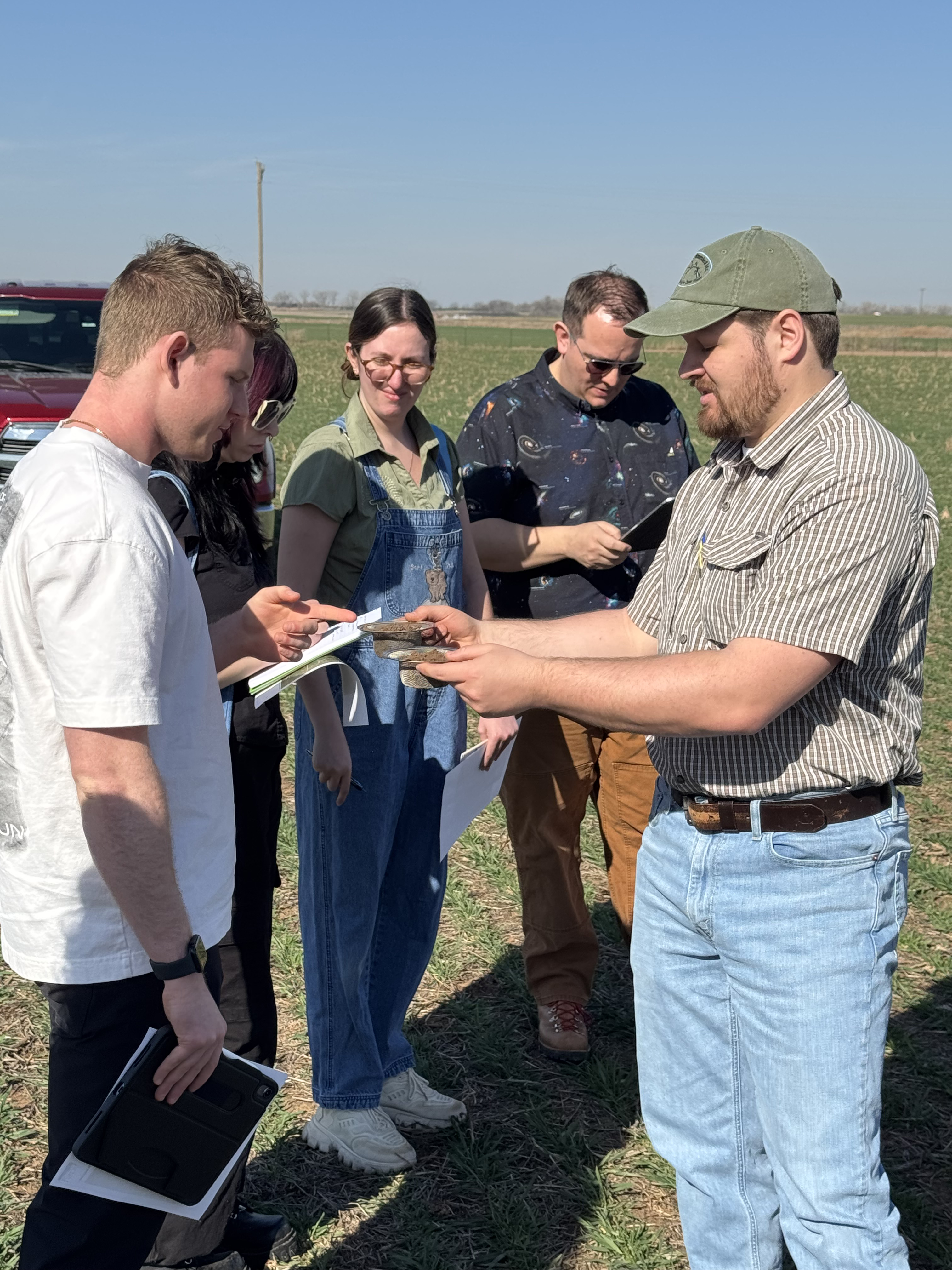 students and soil expert examing the impact of no-till vs till soil