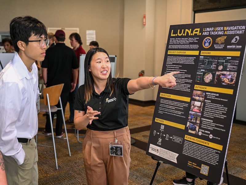 CosmoShox student presenting at a poster session at JSC