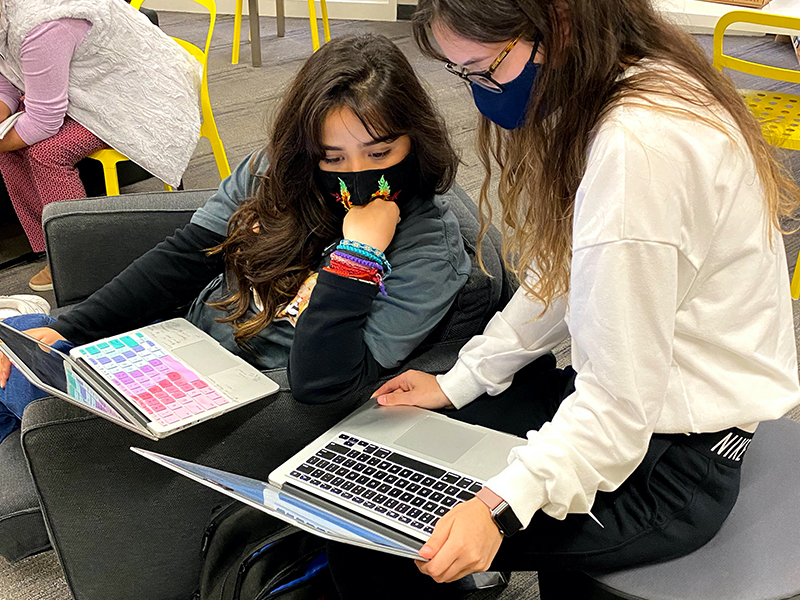 Two females working together, while wearing masks for the NASA SUITS project