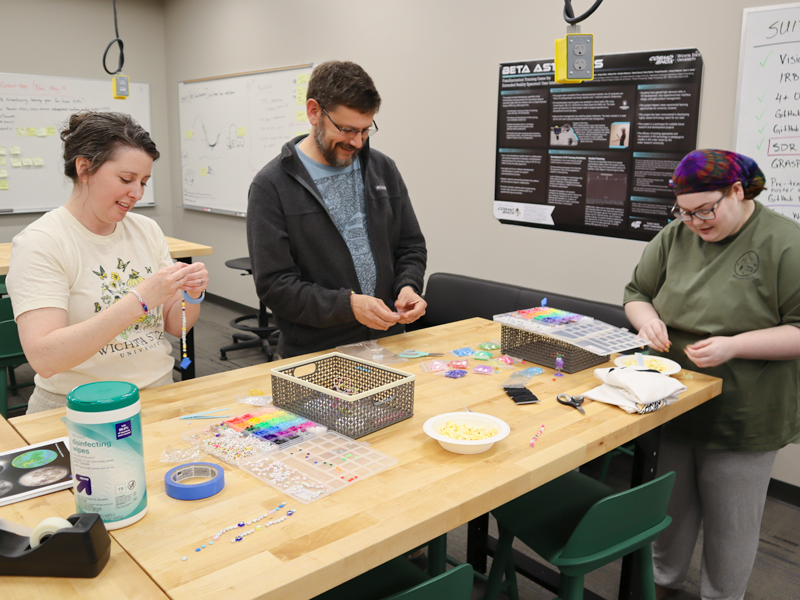 Maggie Schoonover, Dr. William Parcell, and Elaine Duff create friendship bracelets at the Open XR Lab's Open House