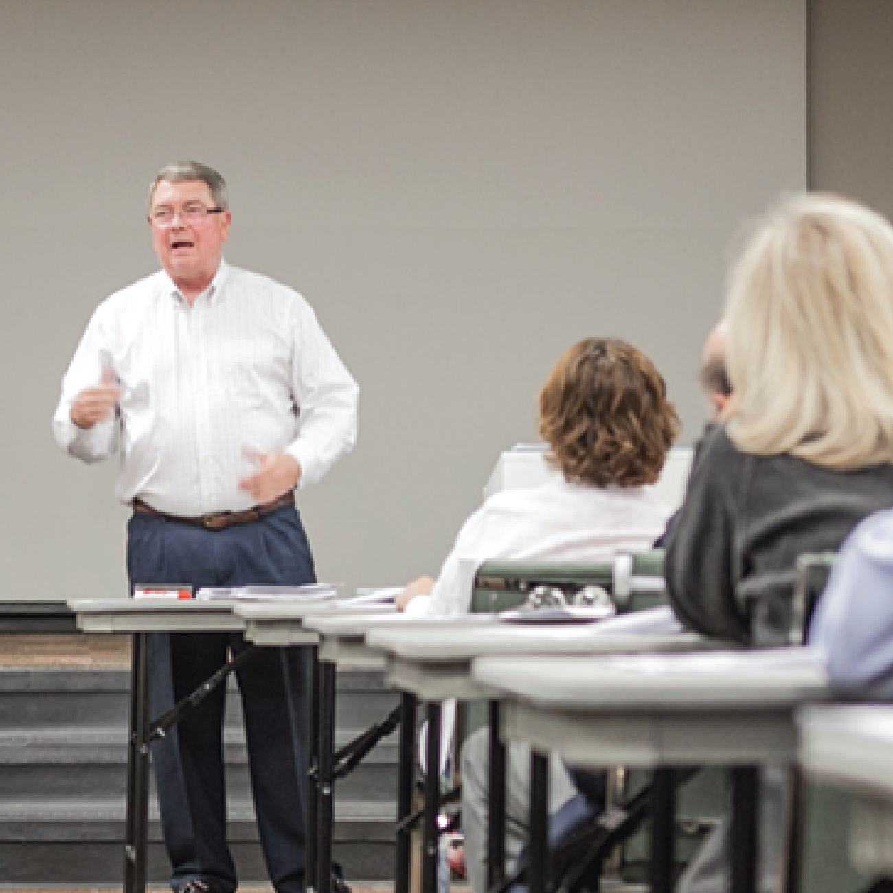 teacher lecturing classroom full of adult learners