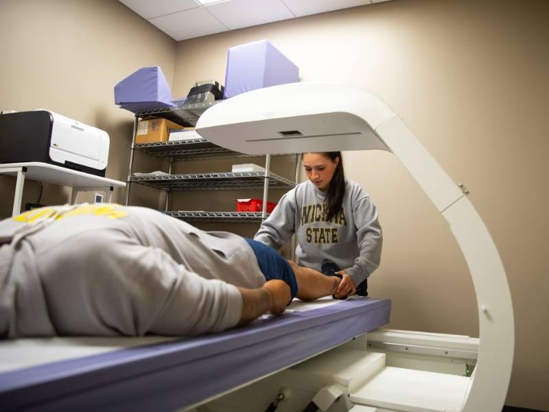 Student scans another person using a dual-energy X-ray absorptiometry (DEXA) machine at Wichita State's Human Performance Lab.