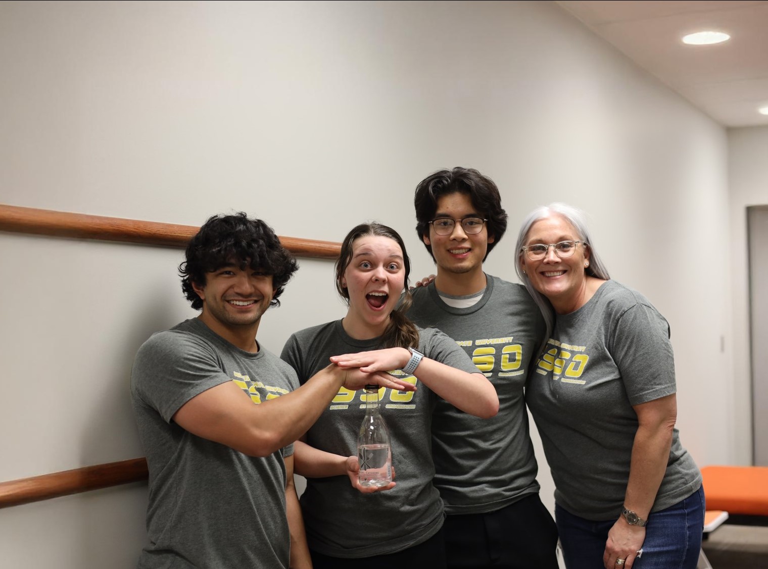 Members of the Exercise Science Student Organization smile while holding up a bottle of water.