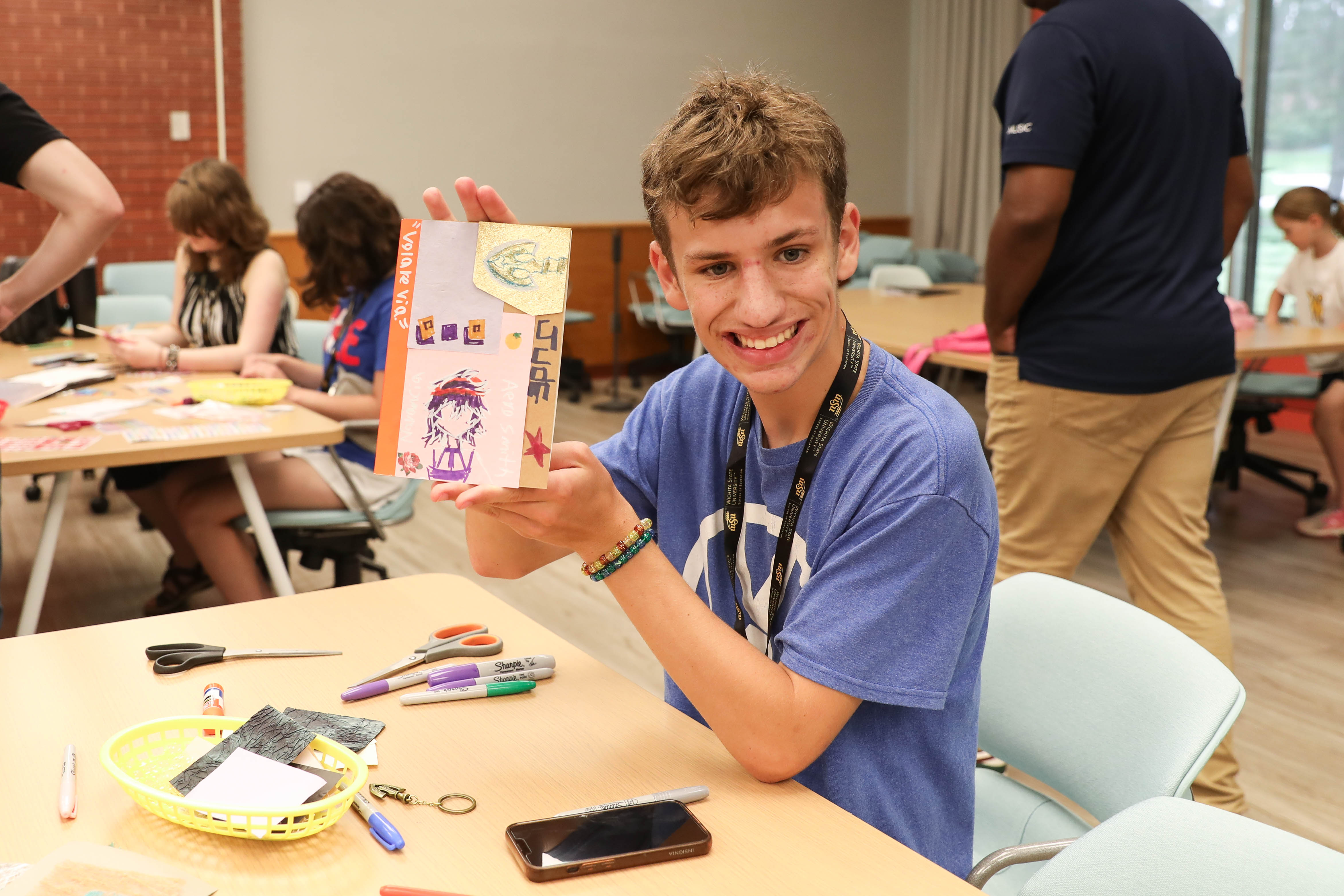 A Wichita State LIFE summer camp participant holds an art project during an activity.