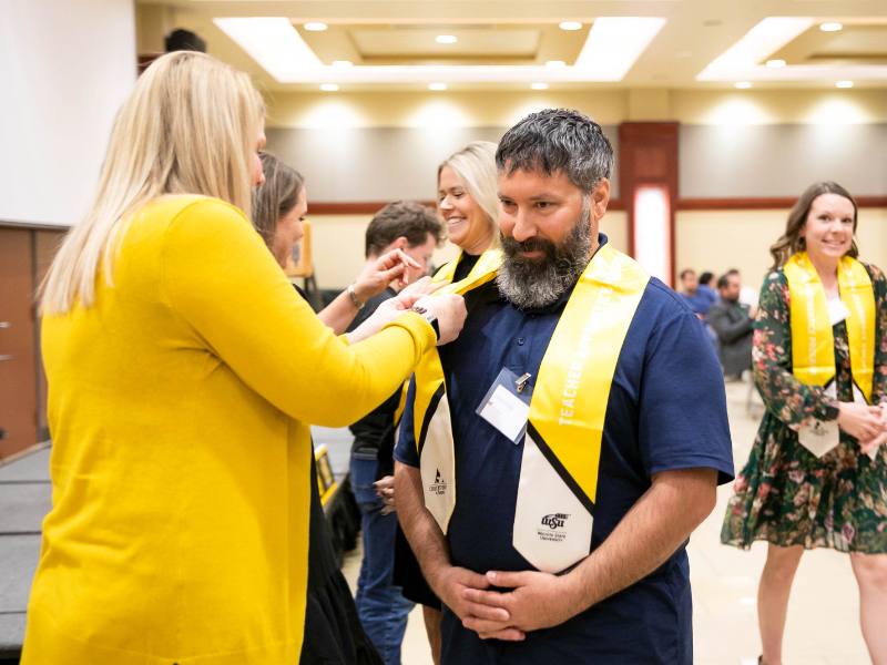 College of Education student receiving TAP pin during graduation at the TAP pinning ceremony