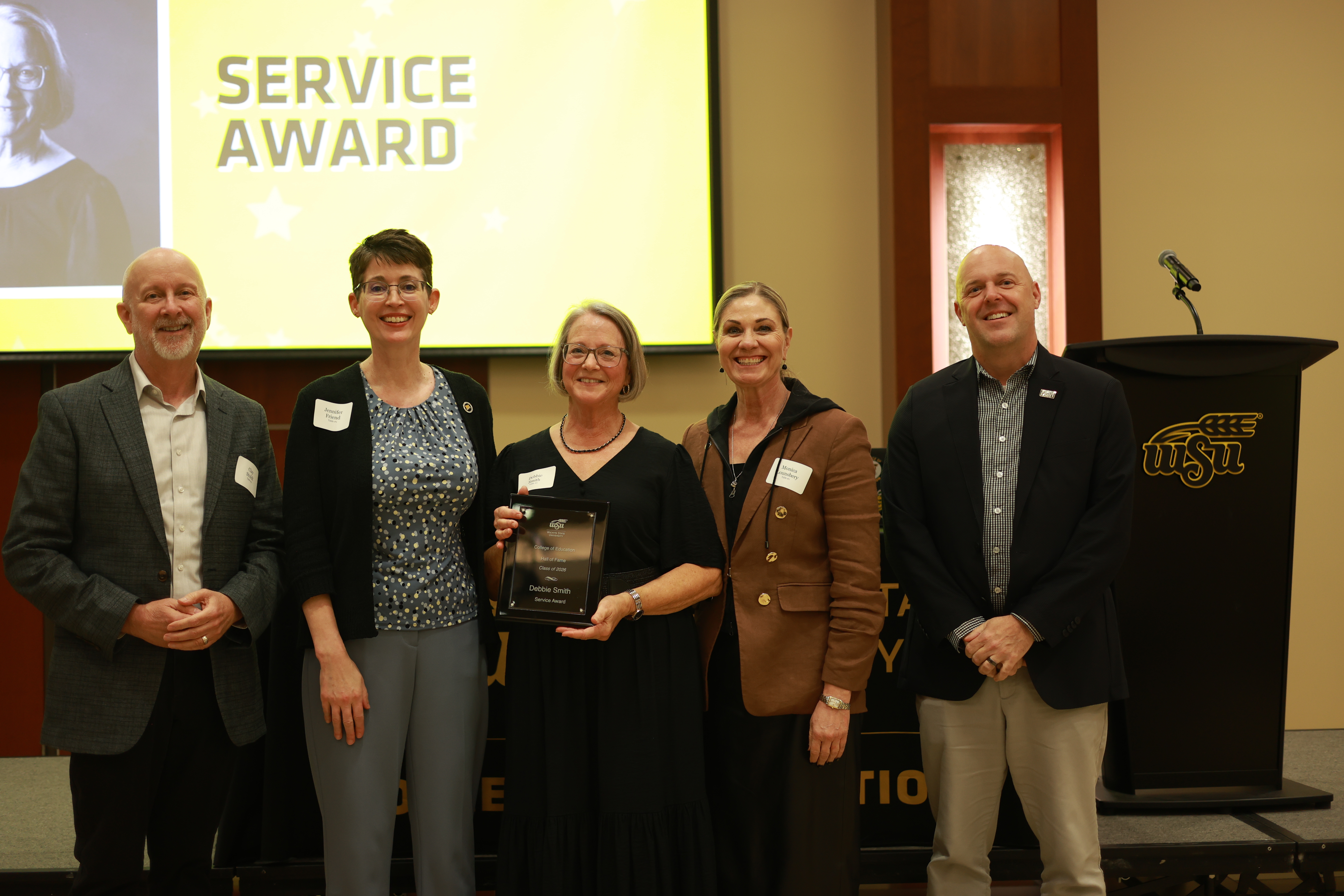 Debbie Smith poses with College of Education and Wichita State leaders after receiving the Service Award at the 2026 Hall of Fame ceremony.