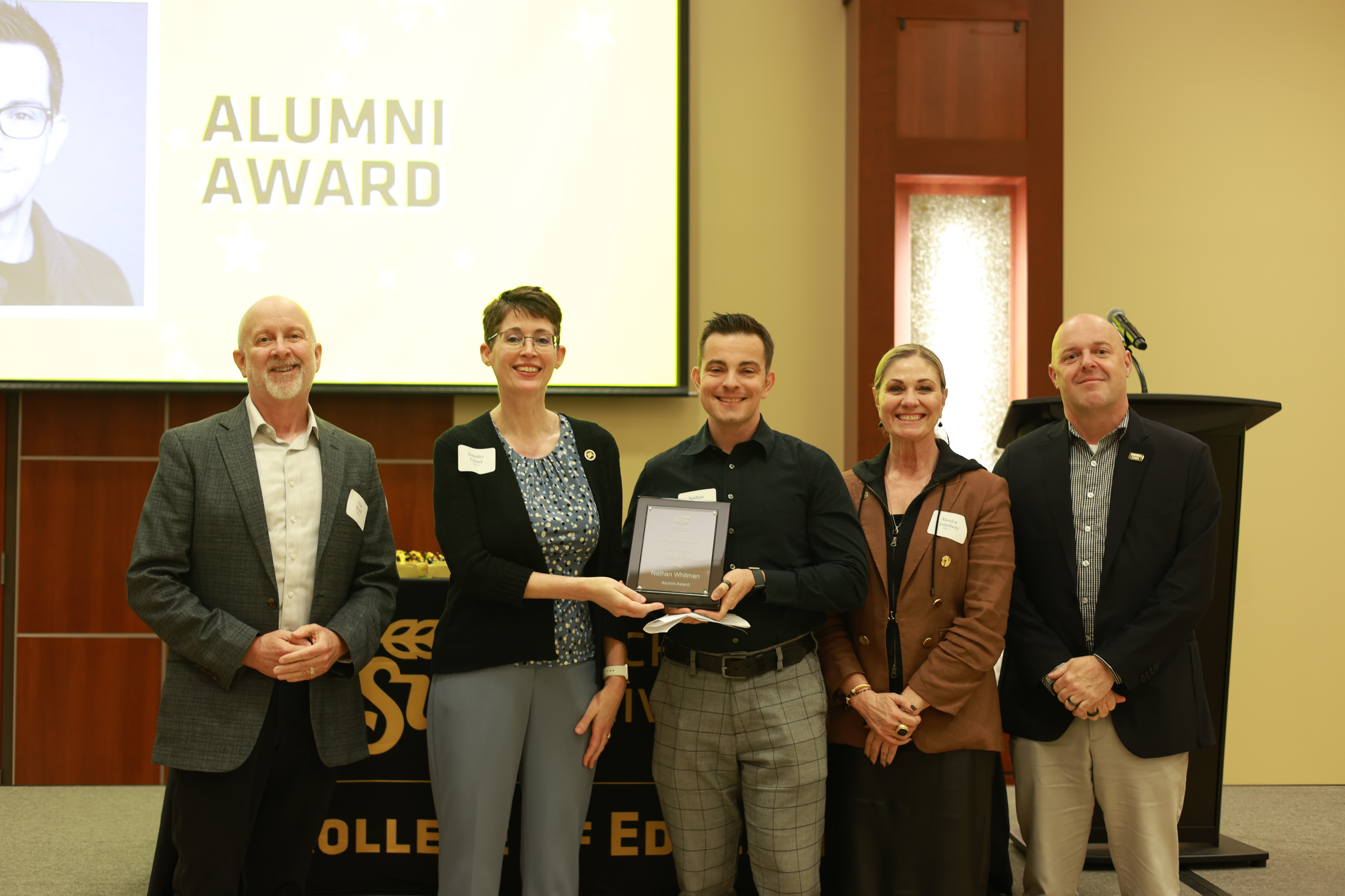 Nathan Whitman poses with College of Education and Wichita State leaders after receiving the Alumni Award at the 2026 Hall of Fame ceremony.