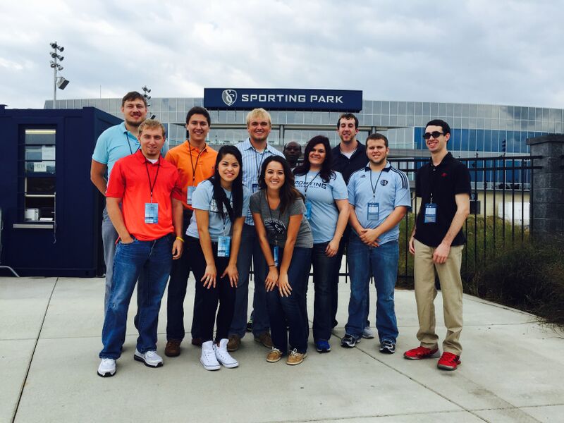 A group gathered together in front of the Sporting Park. 