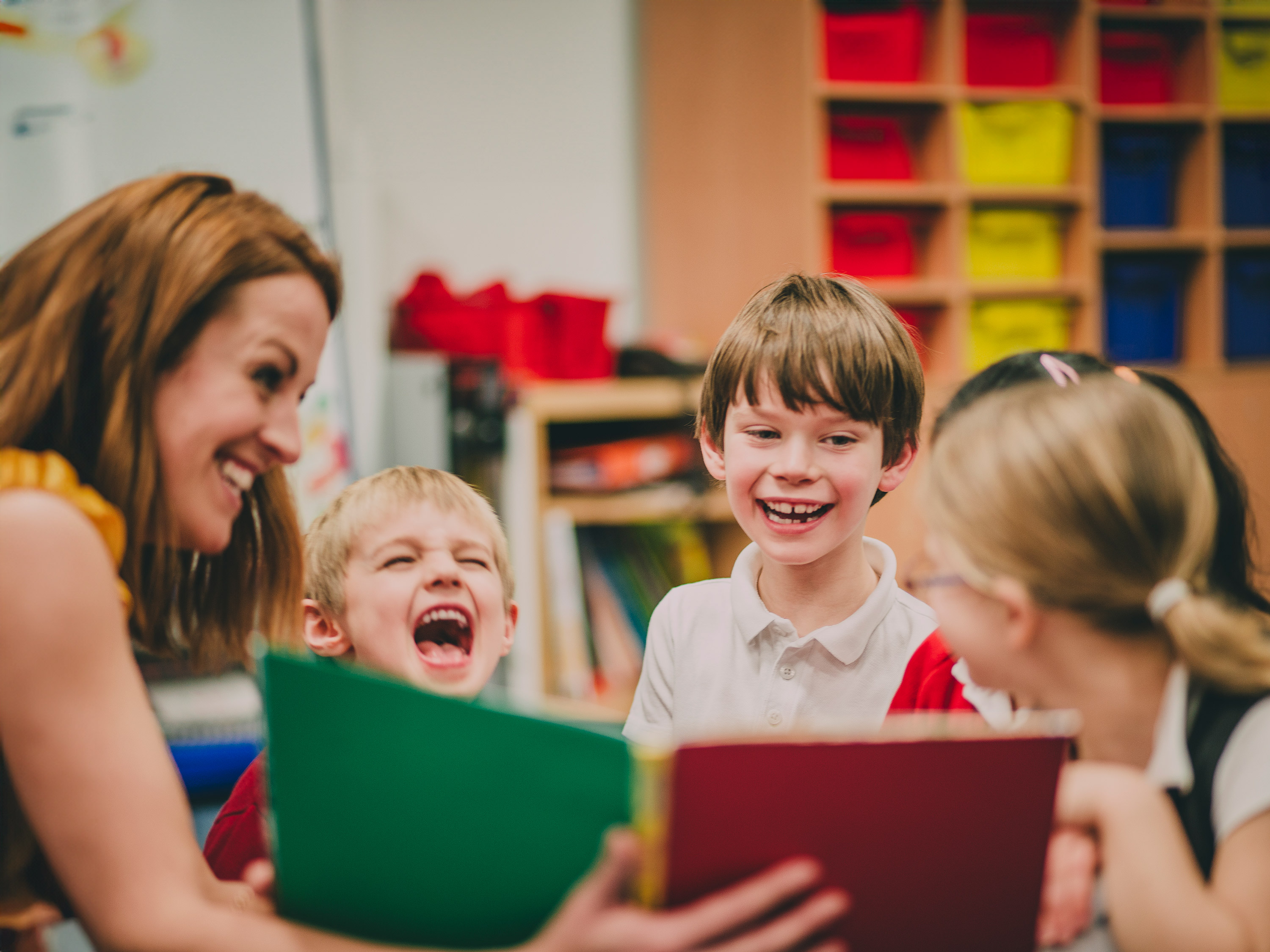 A para reads with a small group of young students