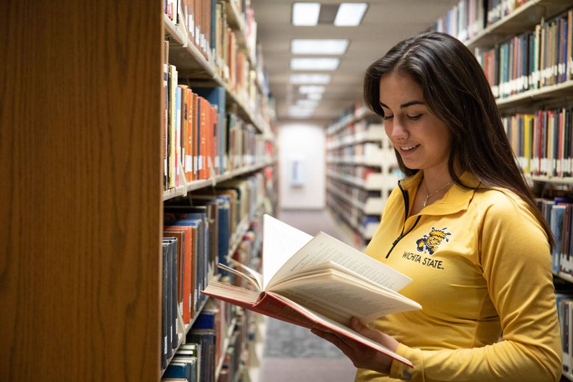 female student reading in library