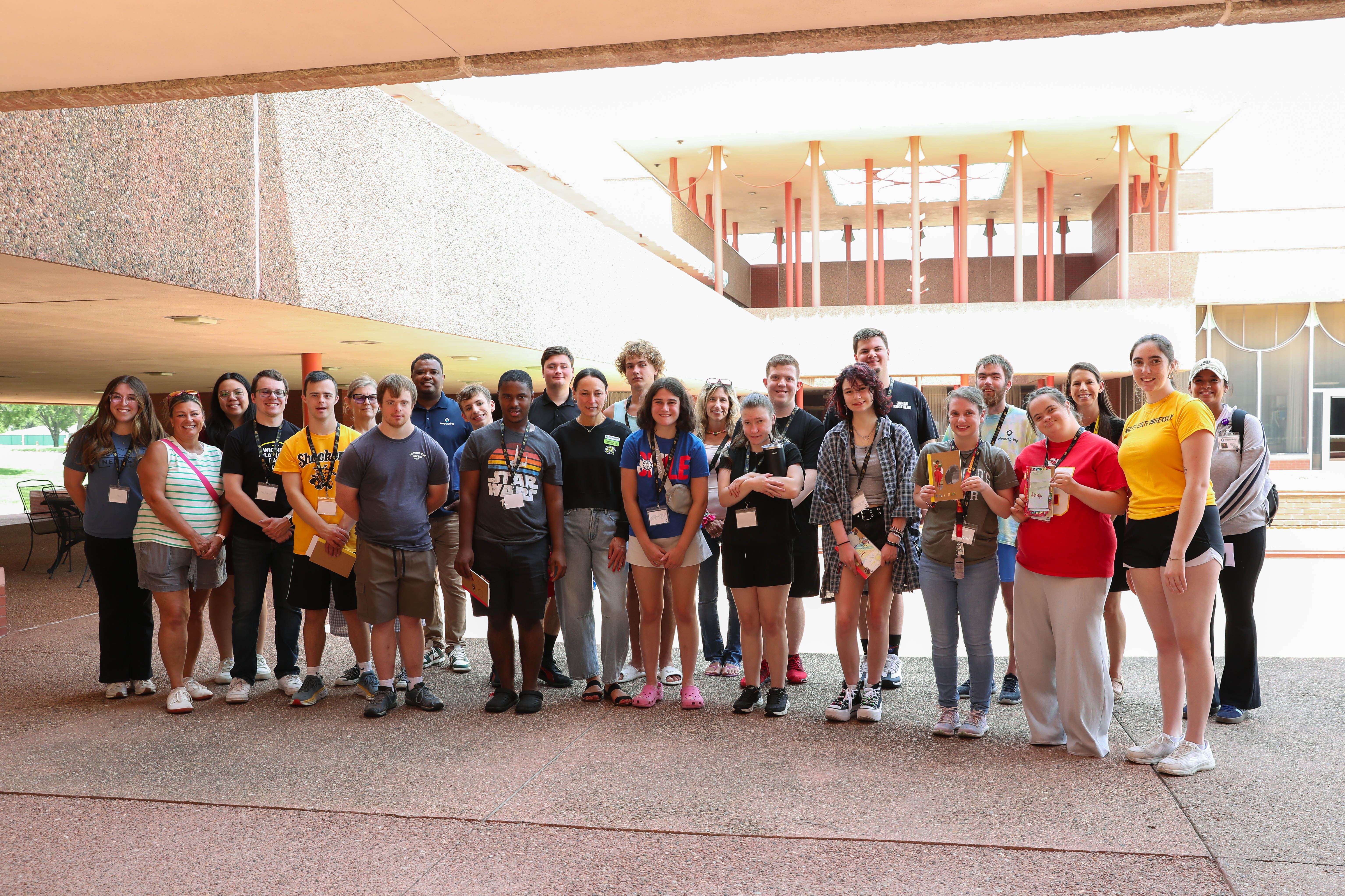 Participants, volunteers, and Wichita State LIFE program staff pose for a photo in front of Corbin Education Building during the Wichita State LIFE summer camp at Wichita State University
