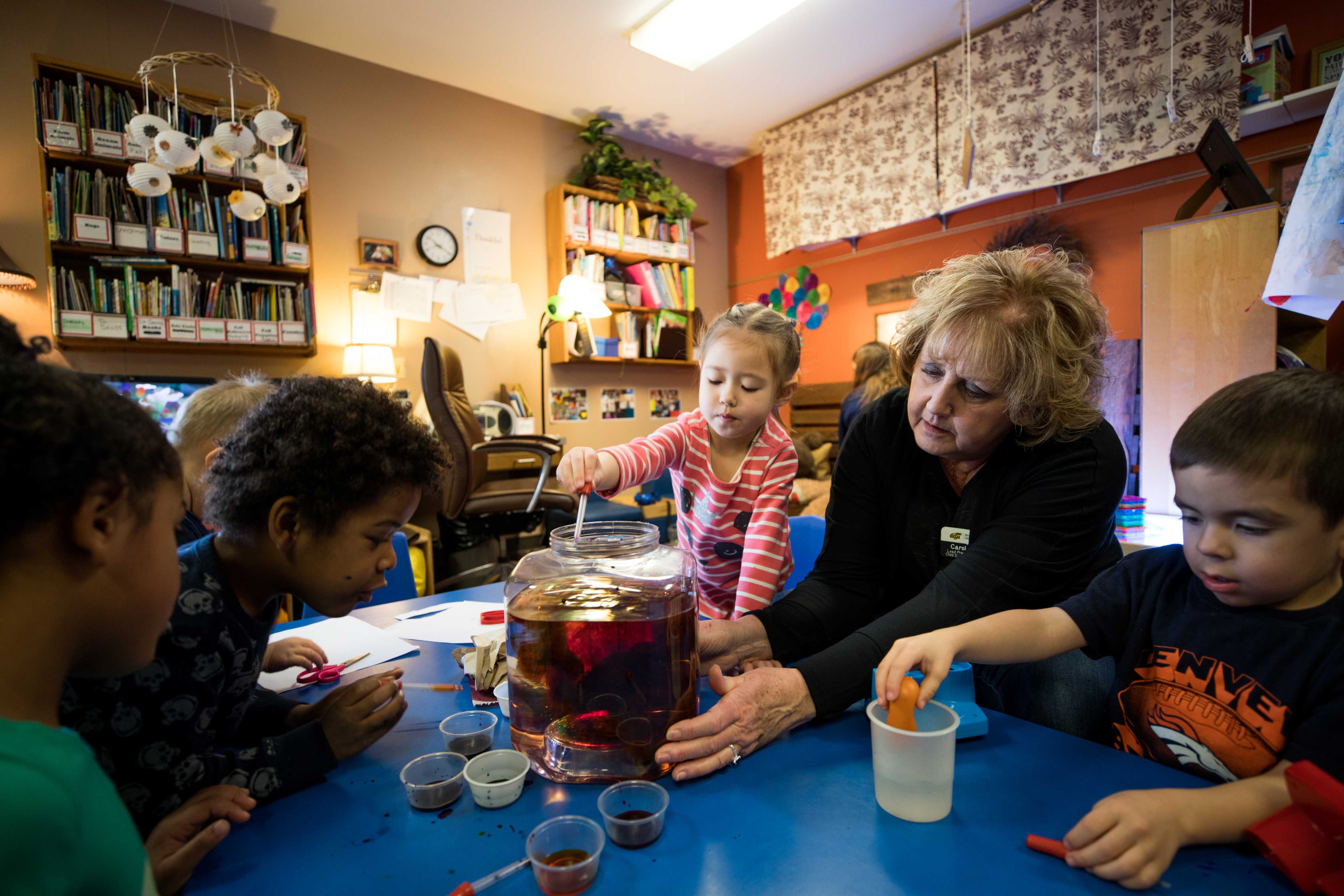 young children dye eggs with the help of a teacher 
