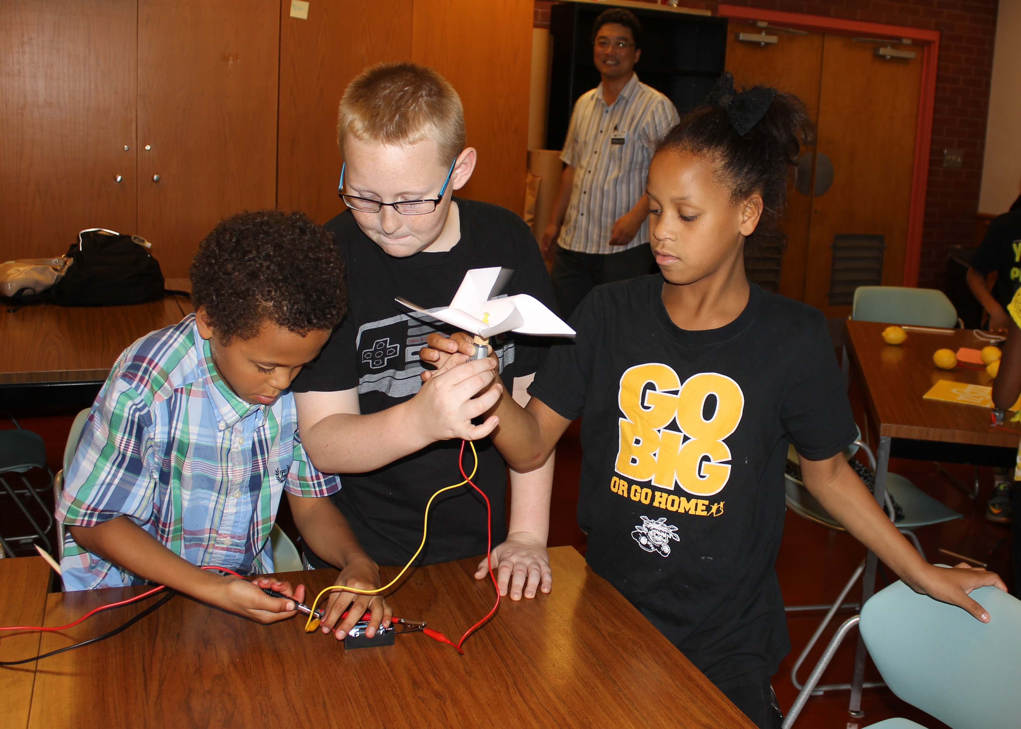 Three students play with a fan