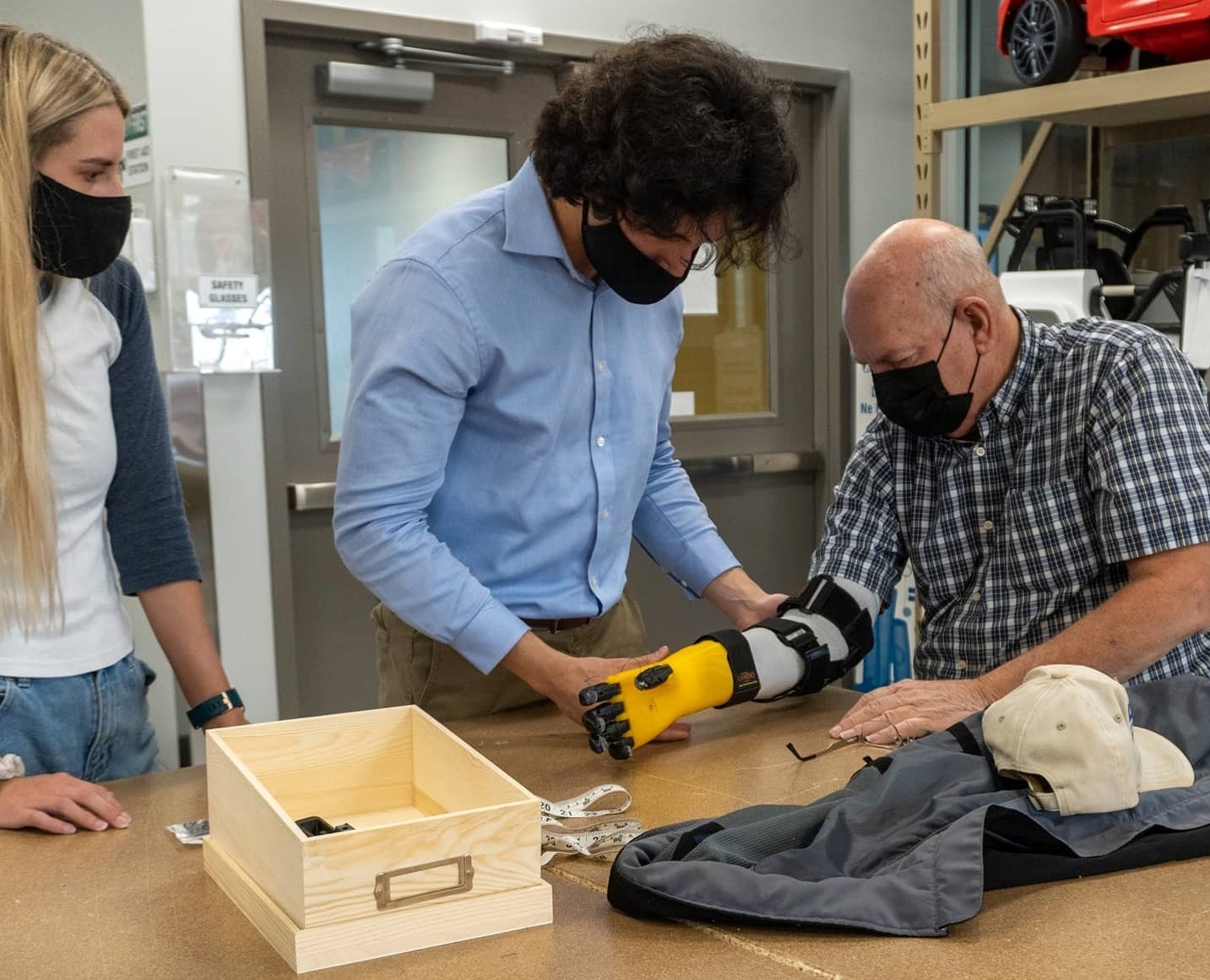 Older man trying out a new 3D-printed prosthetic hand