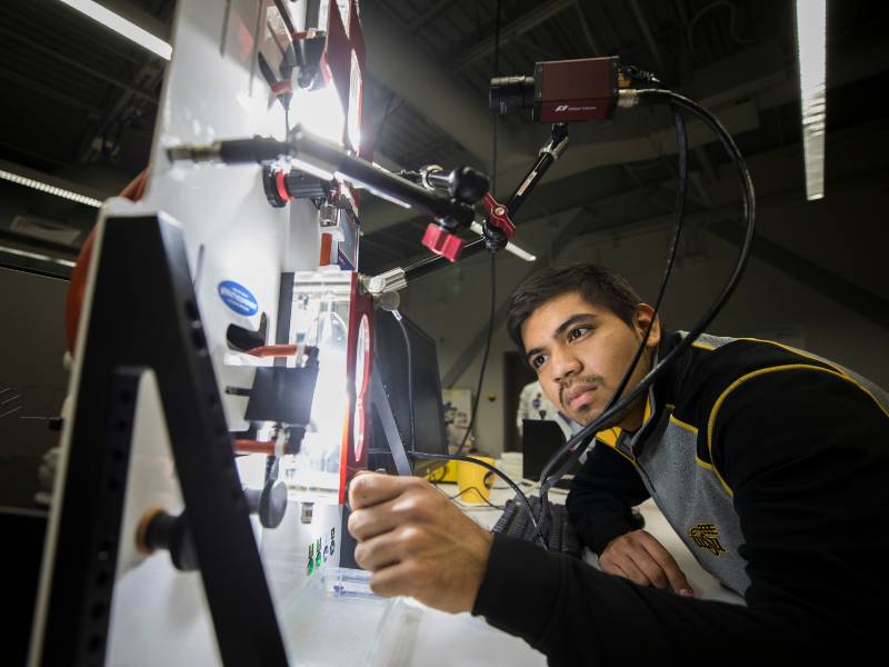 a young man looks at a machine