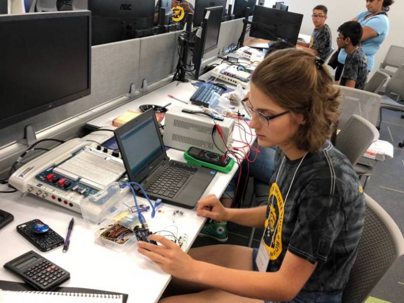 A young woman works on an Arduino computer