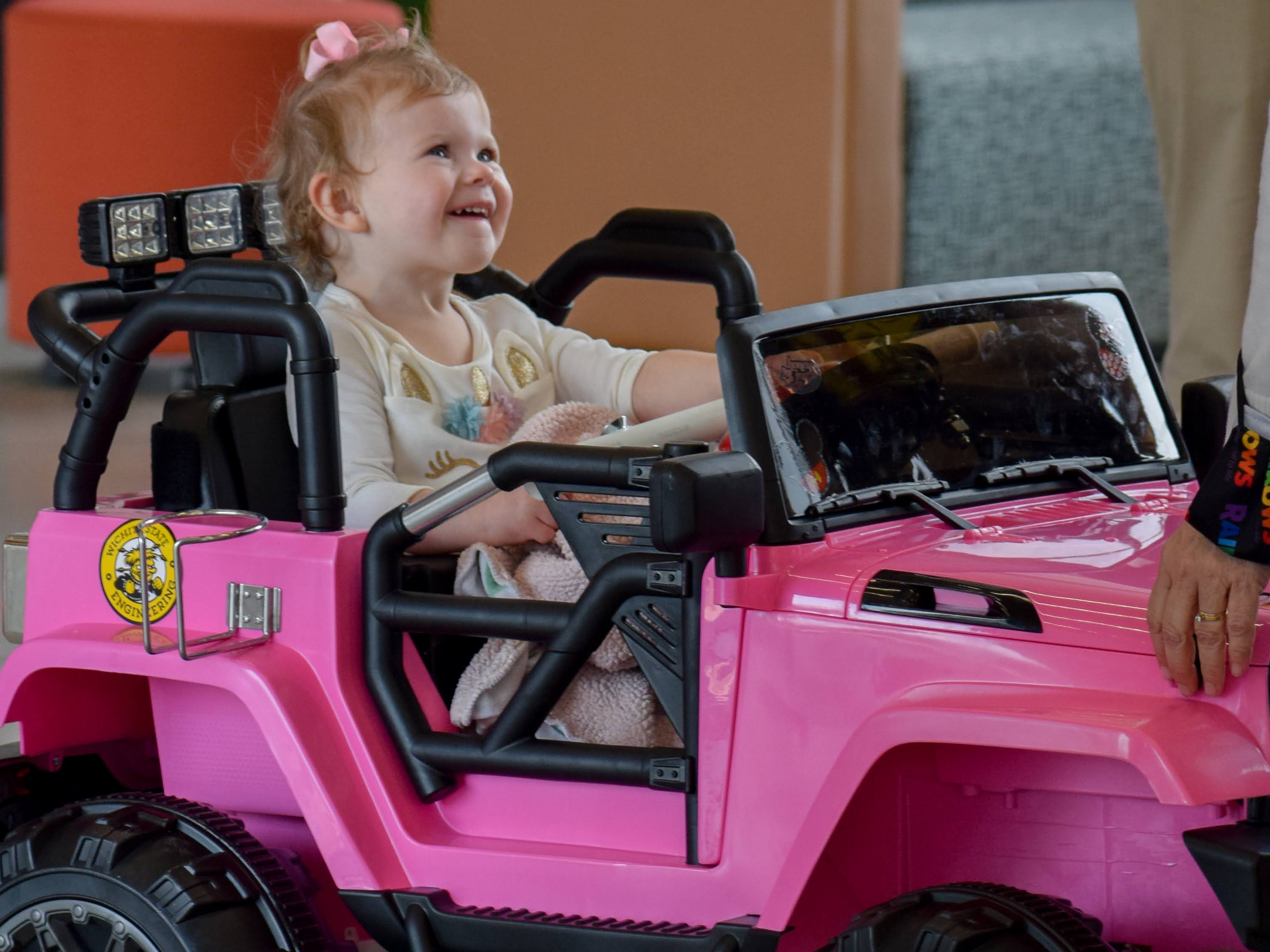 Little girl driving a toy ride-on car from GoBabyGo
