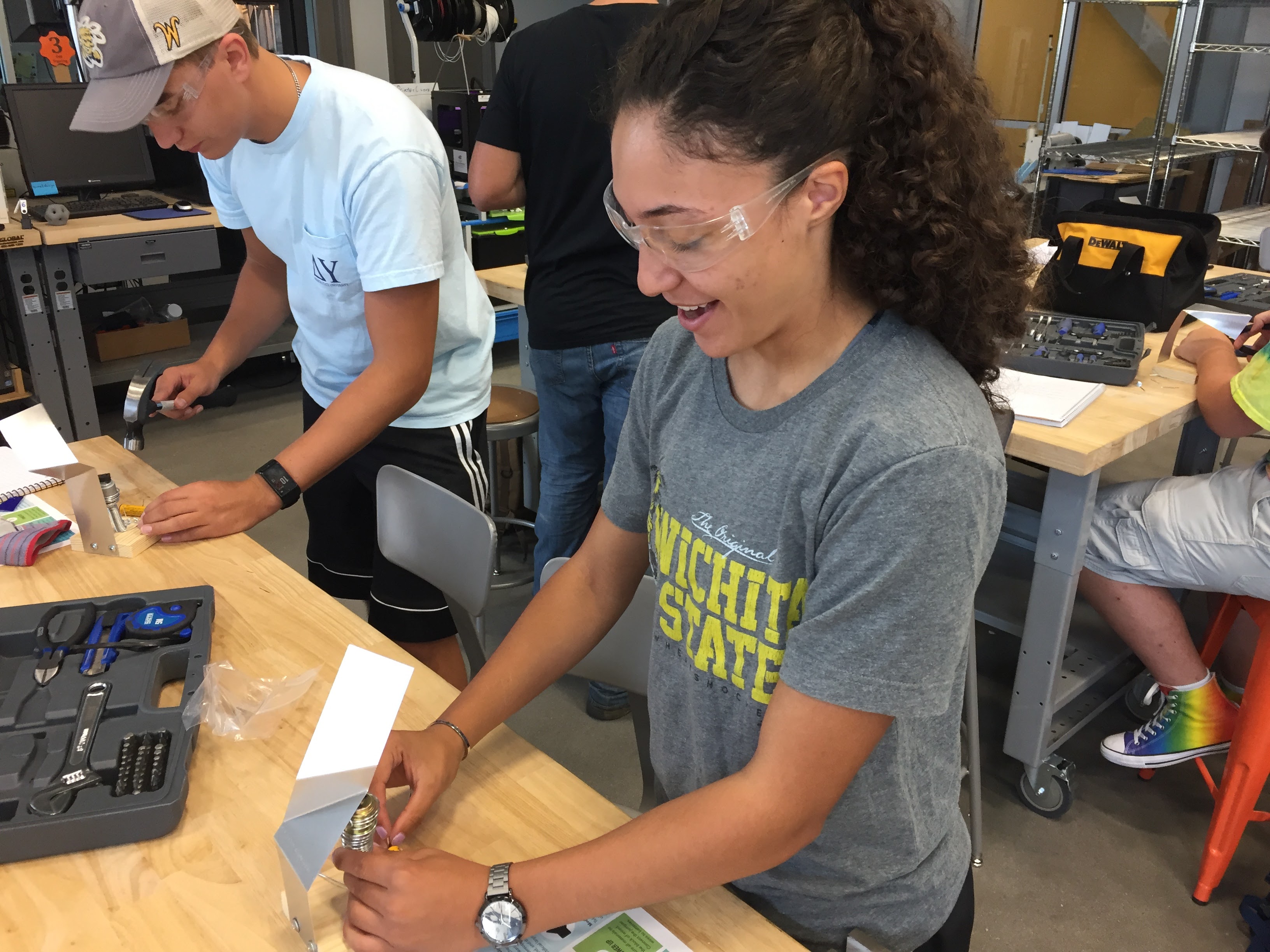 Students build with hand tools at a workbench.
