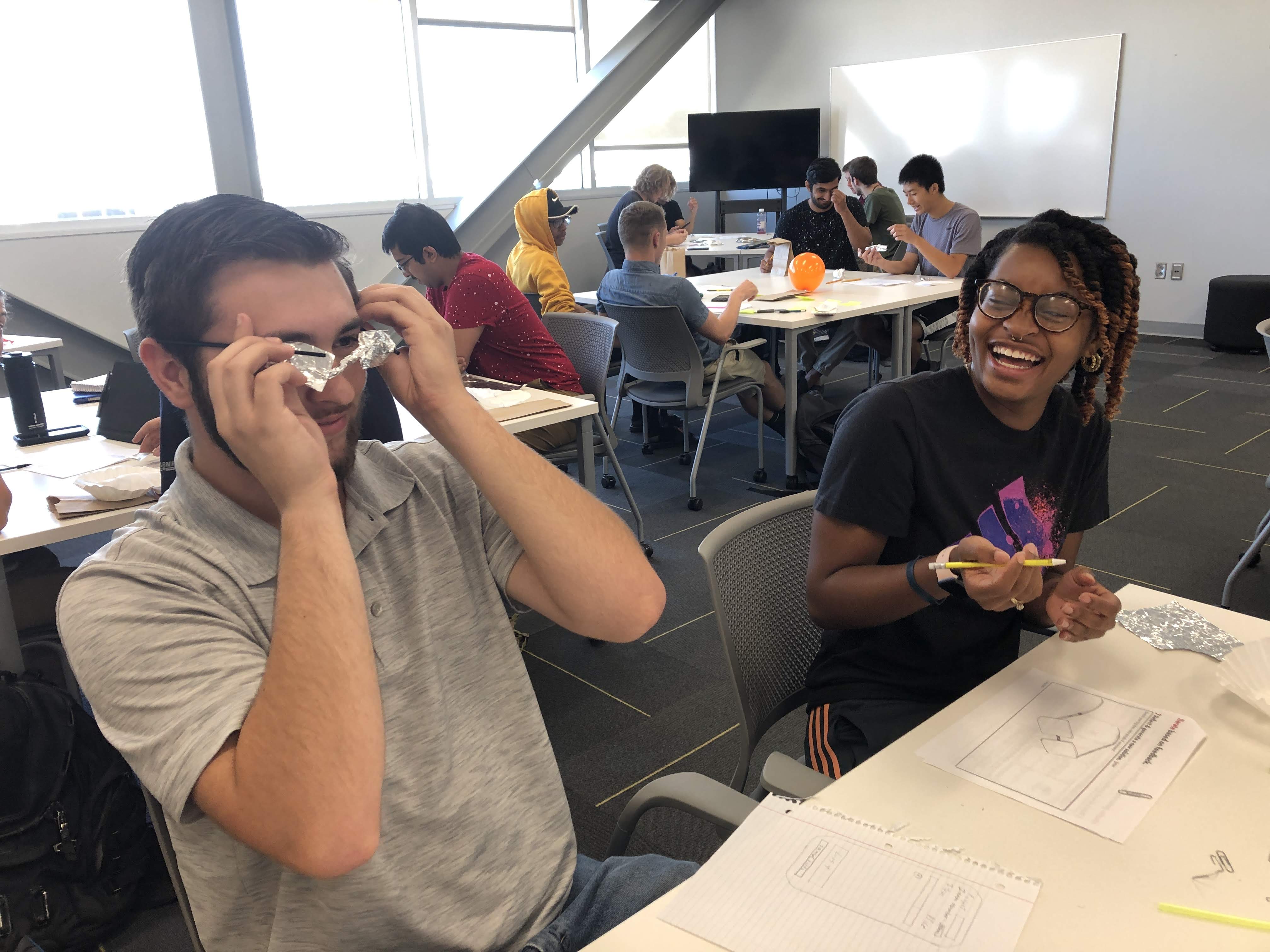 Students sitting at a table laughing about a shared activity