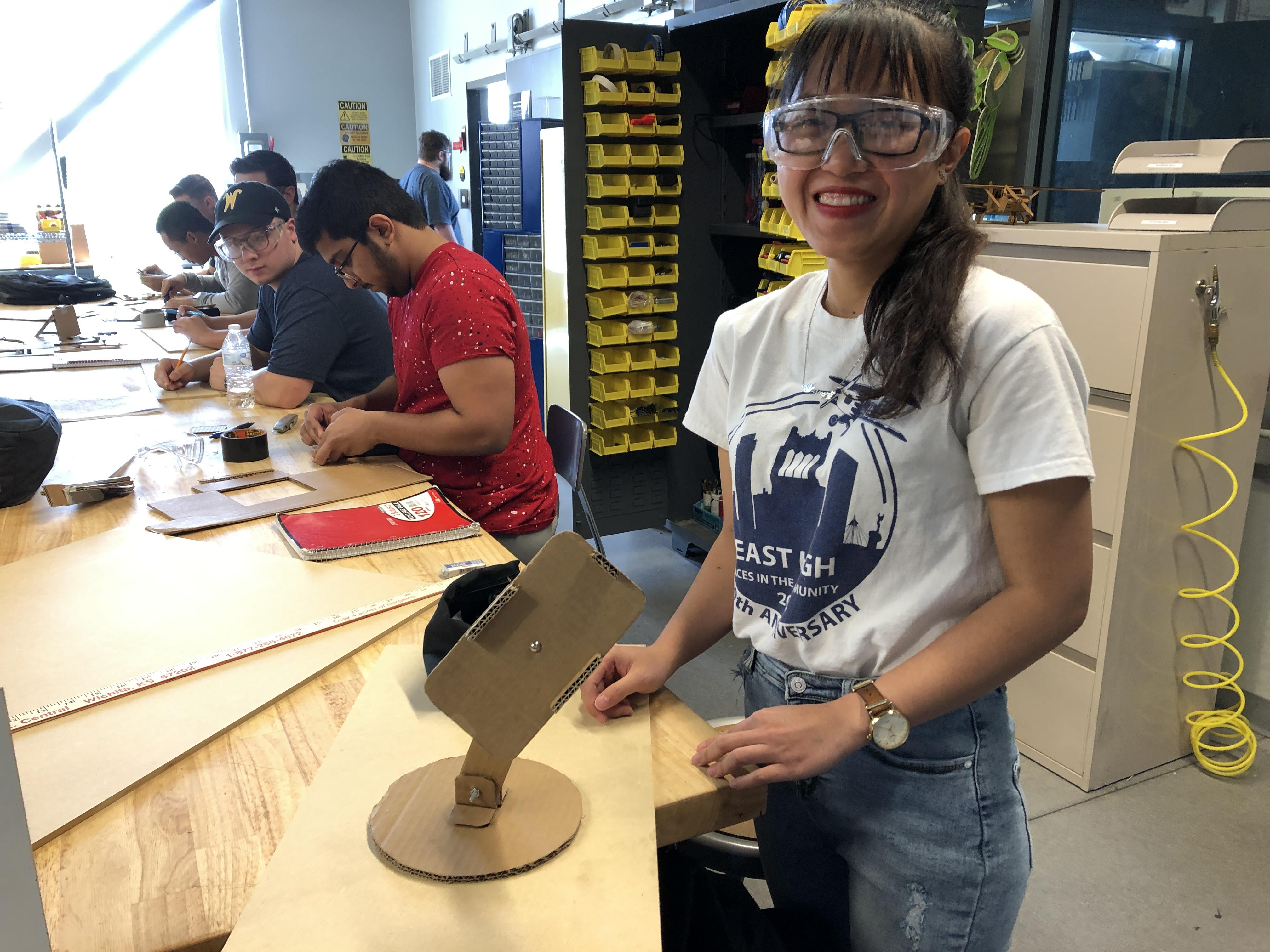 A students shows off her cardboard prototype