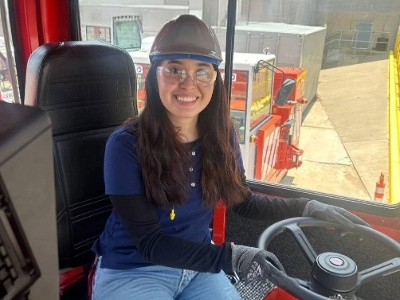 Student wearing construction hat driving vehicle