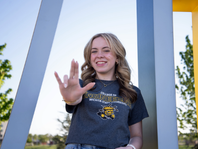 Student posing giving Shocker hand sign