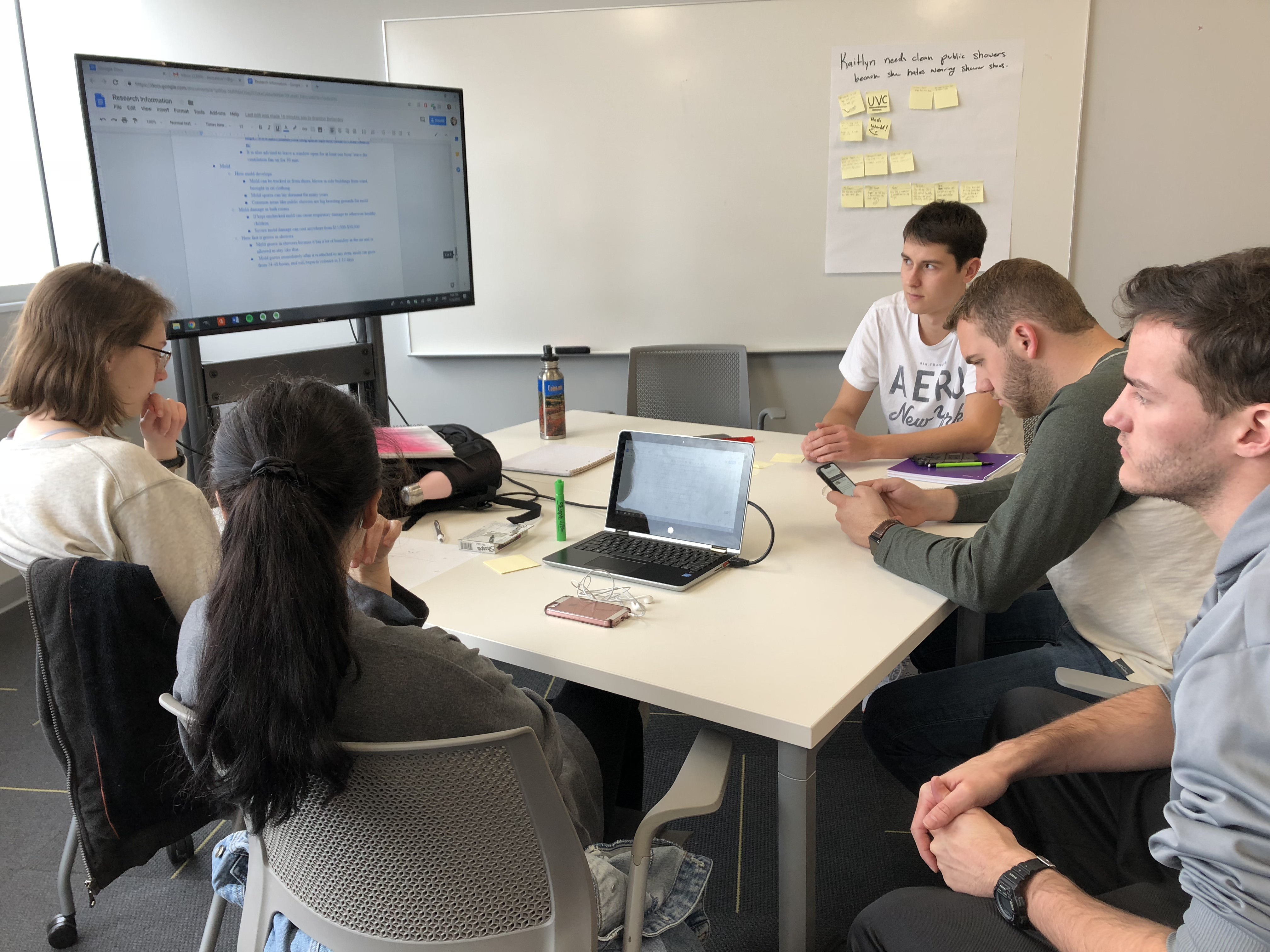 Students collaborating on a shared document on a TV monitor