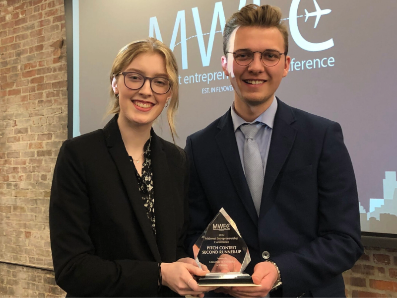 Two students posing with award.