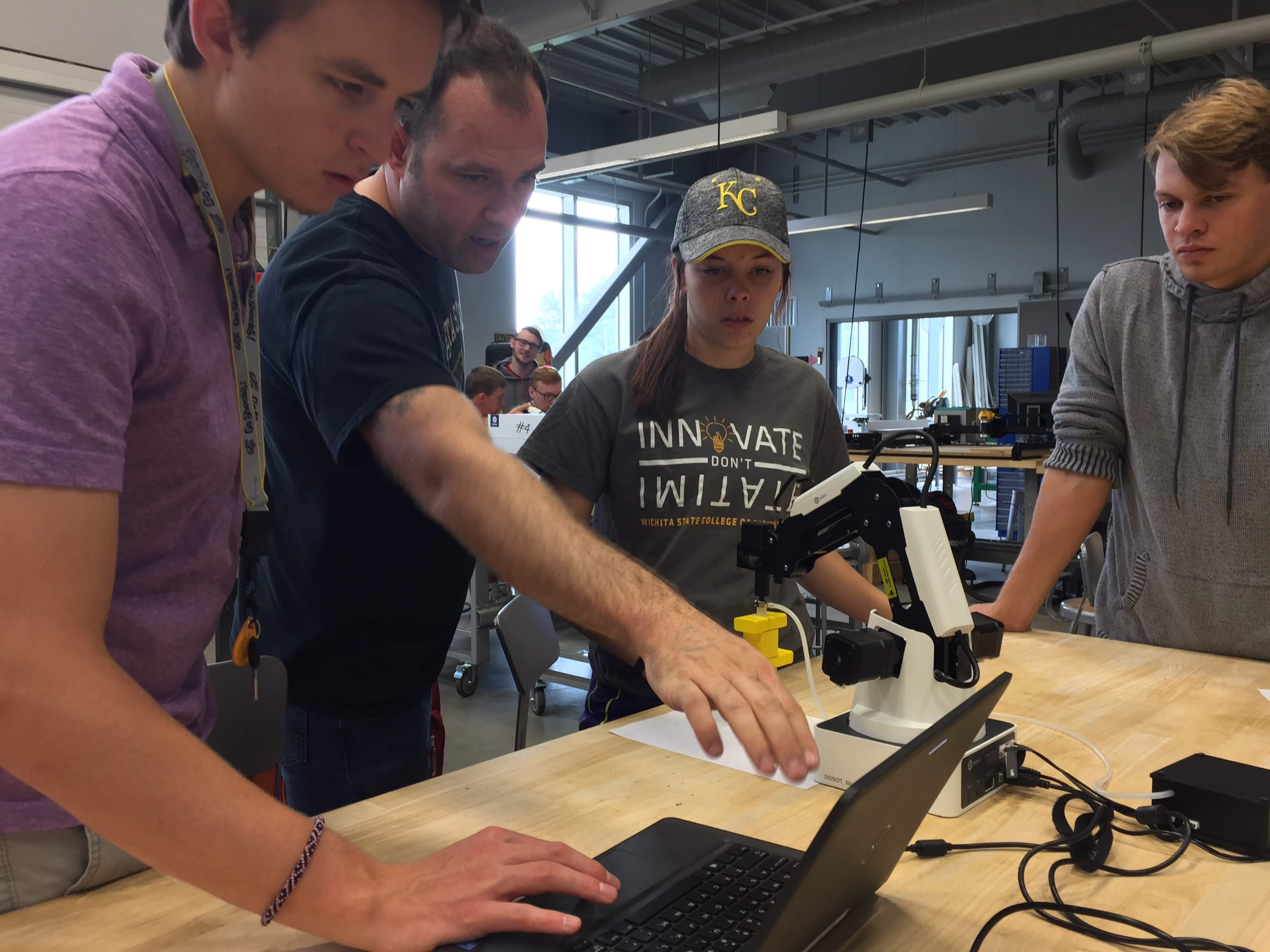 Students getting assistance on programming a robot.