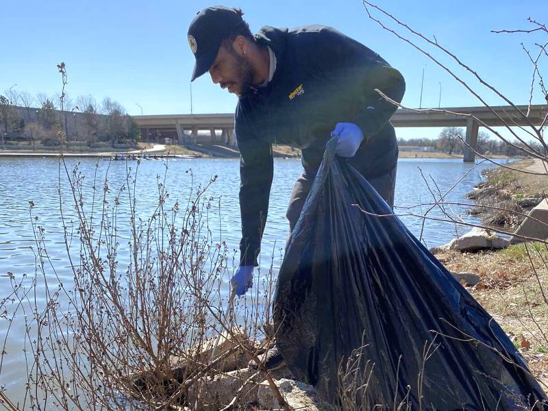 1 volunteer picking up trash along the Arkansas river