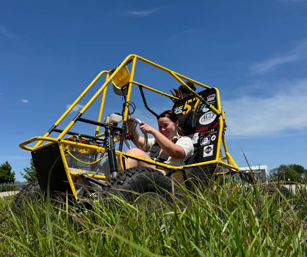 A team member driving a Baja vehicle