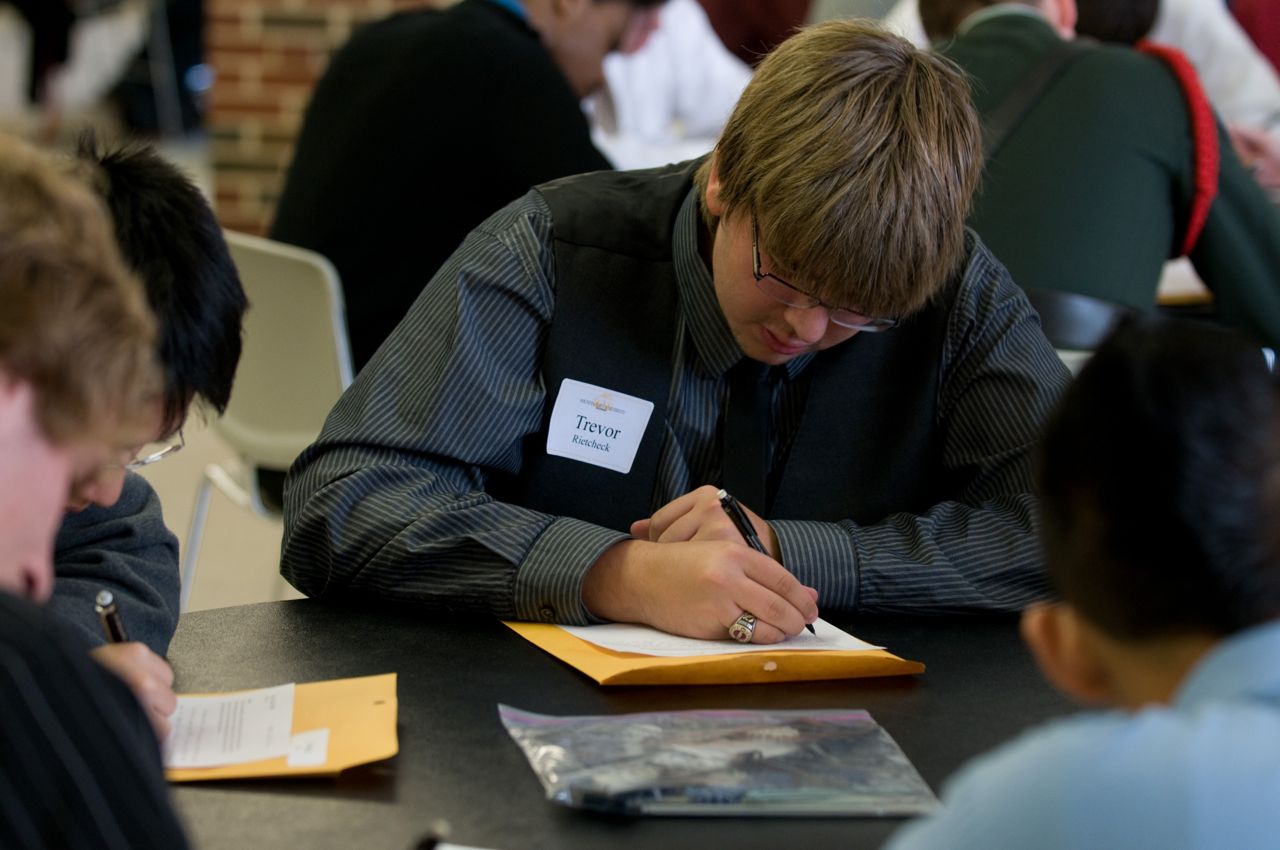 Students write essays at the competition.