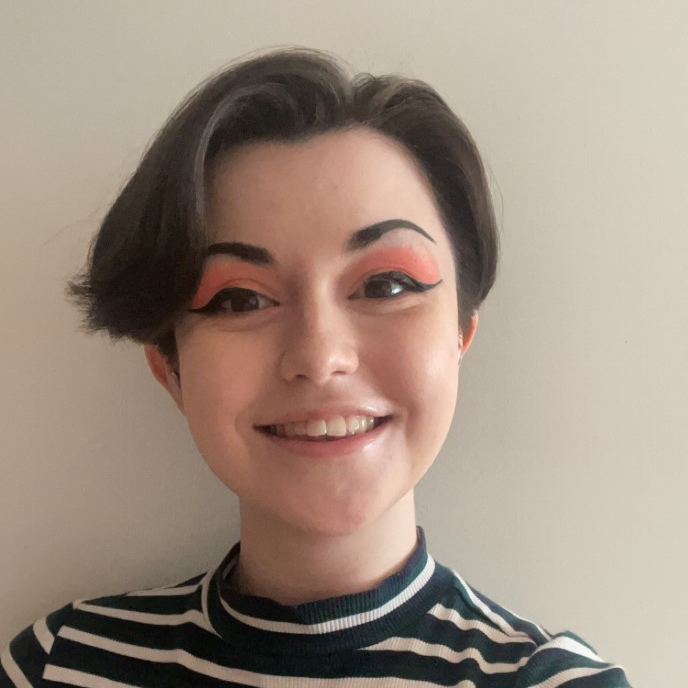 picture of a smiling person with bold eyeliner
