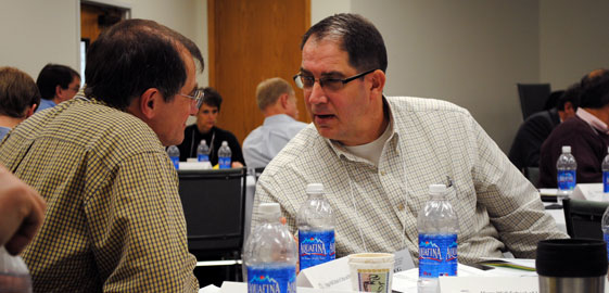 Graduate students sitting at a table while attending an event.