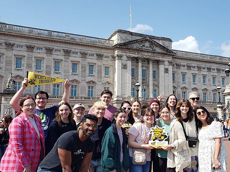 Students and faculty in front of Buckingham Palace holding WuShock and WSU signs