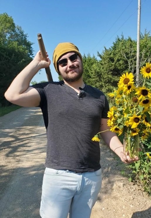 man holding shovel and flowers