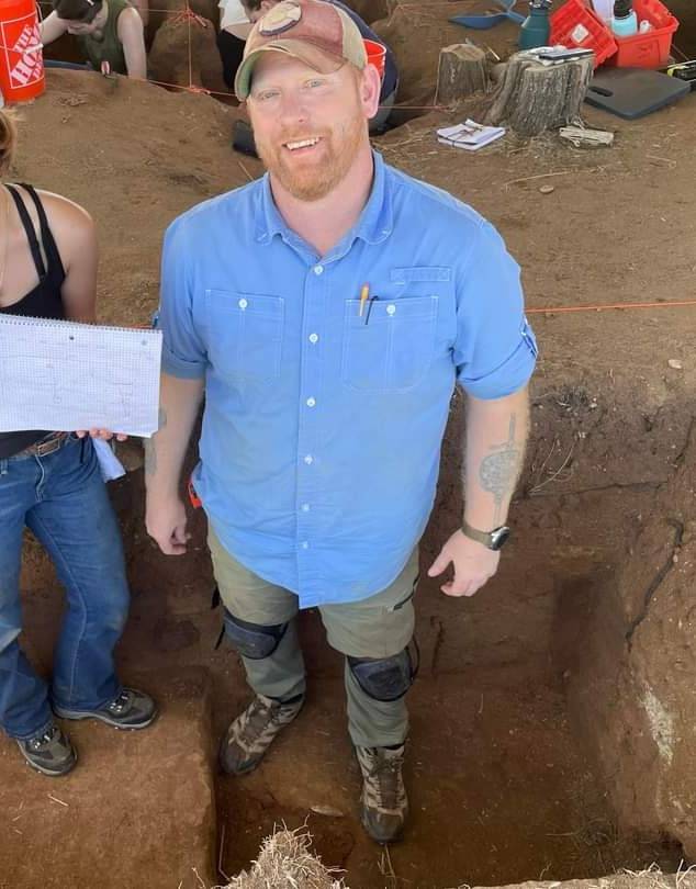 man with facial hair and hat standing in a pit