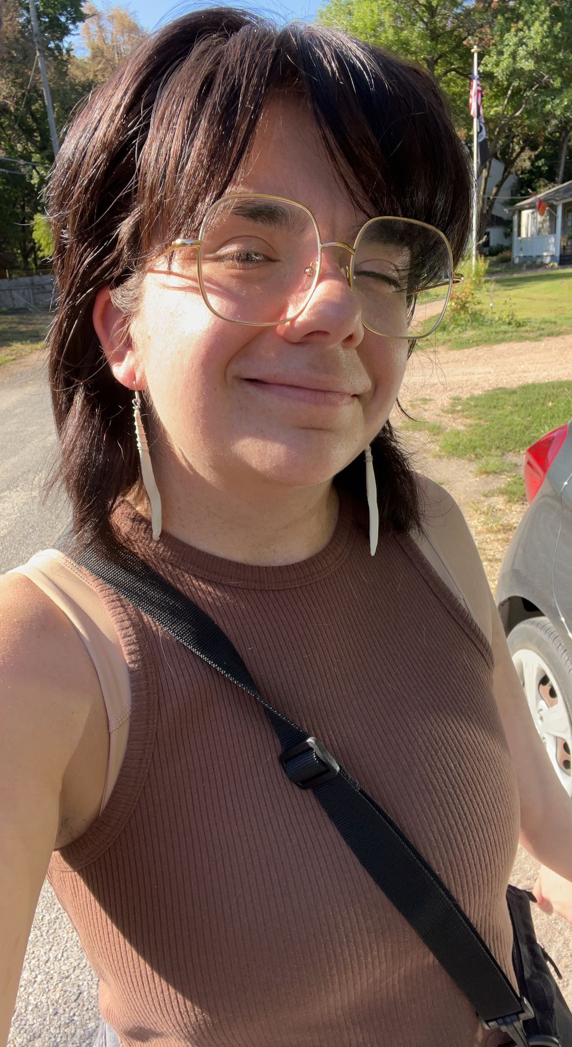 person with dark hair and earring smiling