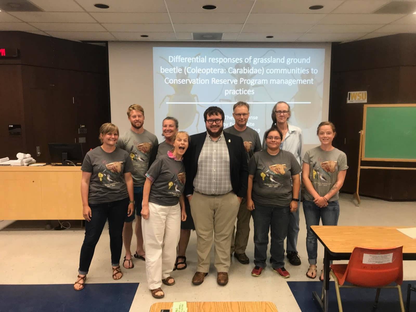 Image of a group of individuals standing in front of projecter screen