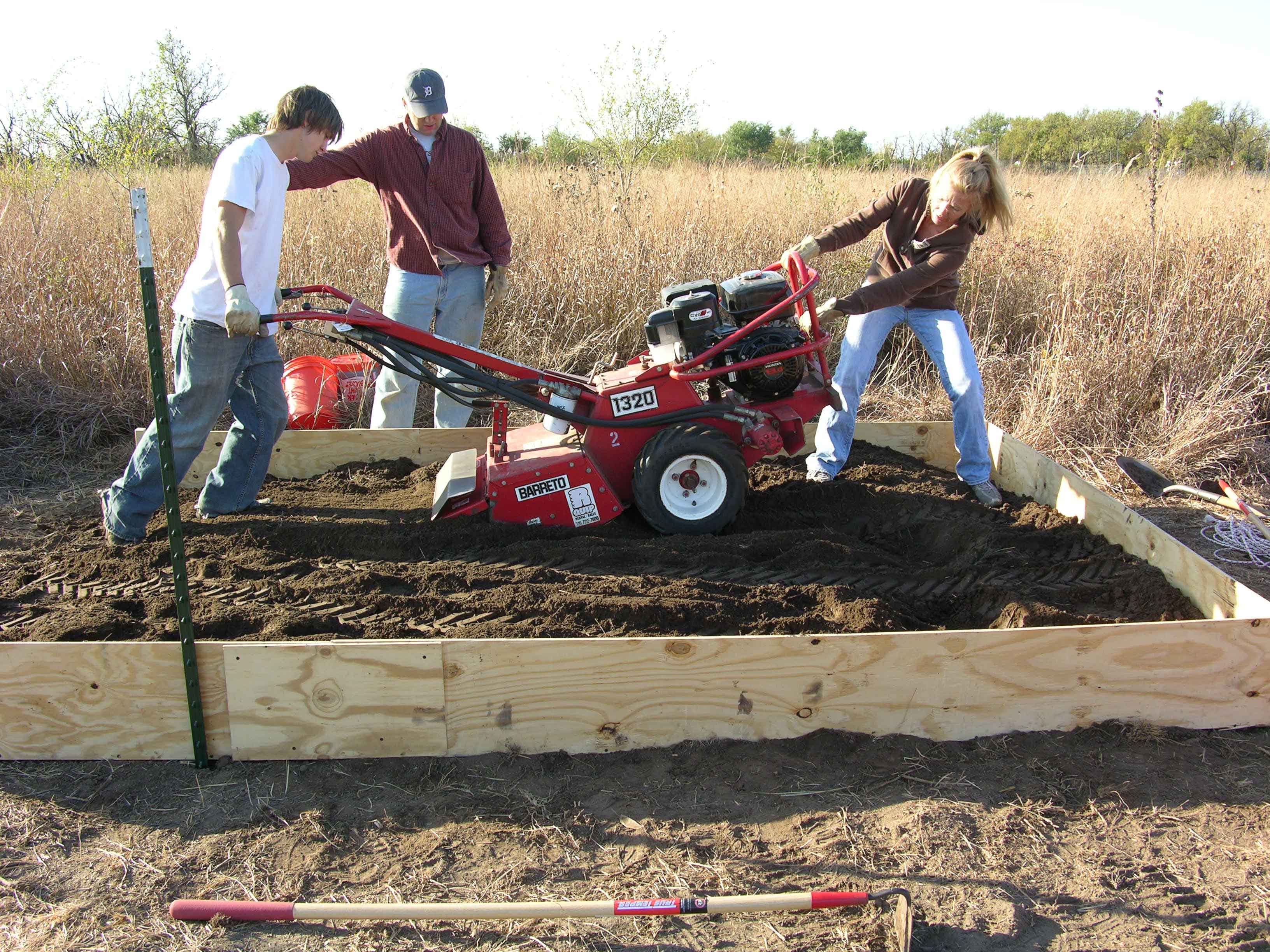 researchers tilling plot