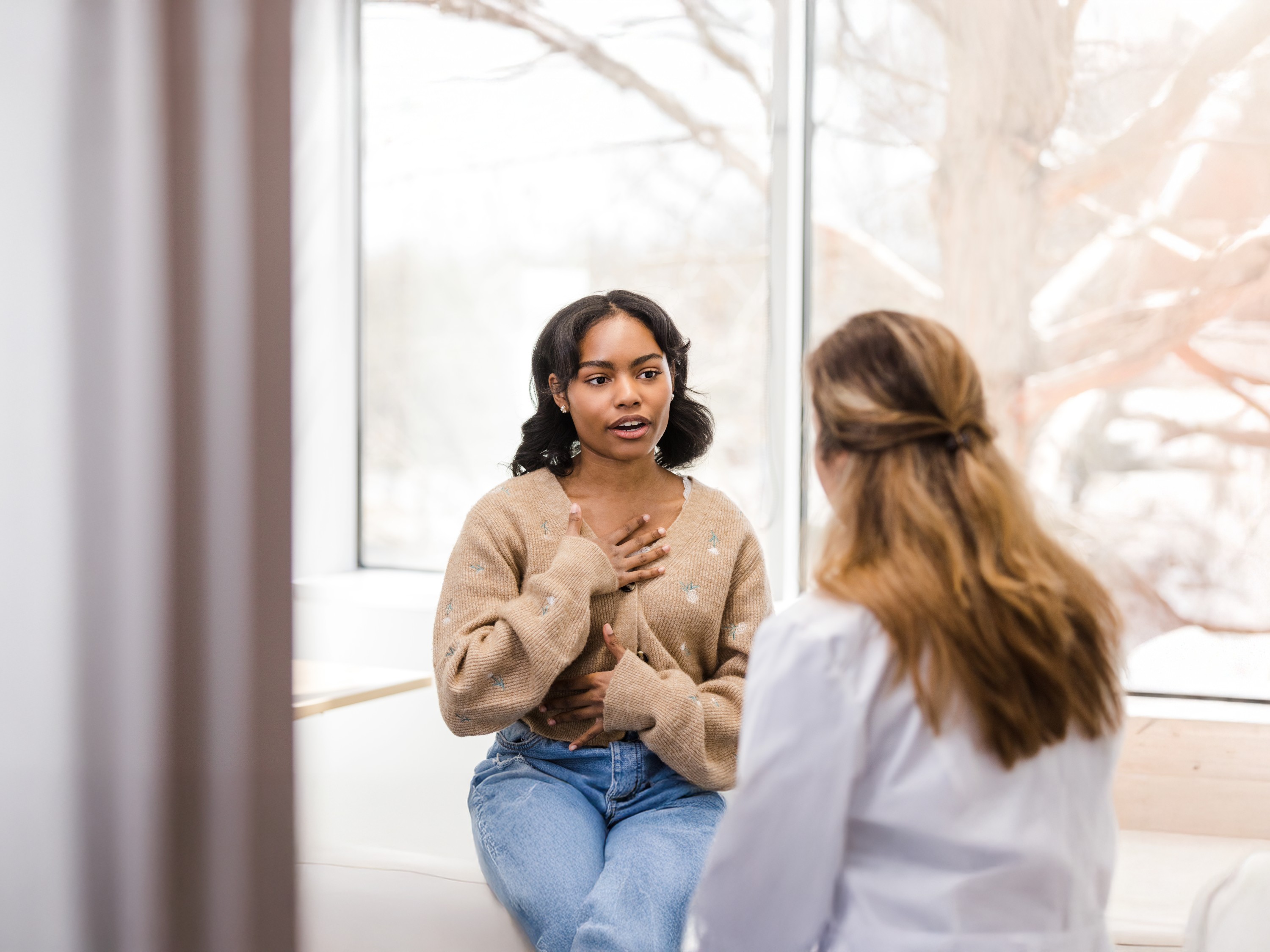 University student motions towards her chest as she describes the discomfort she has been experiencing.