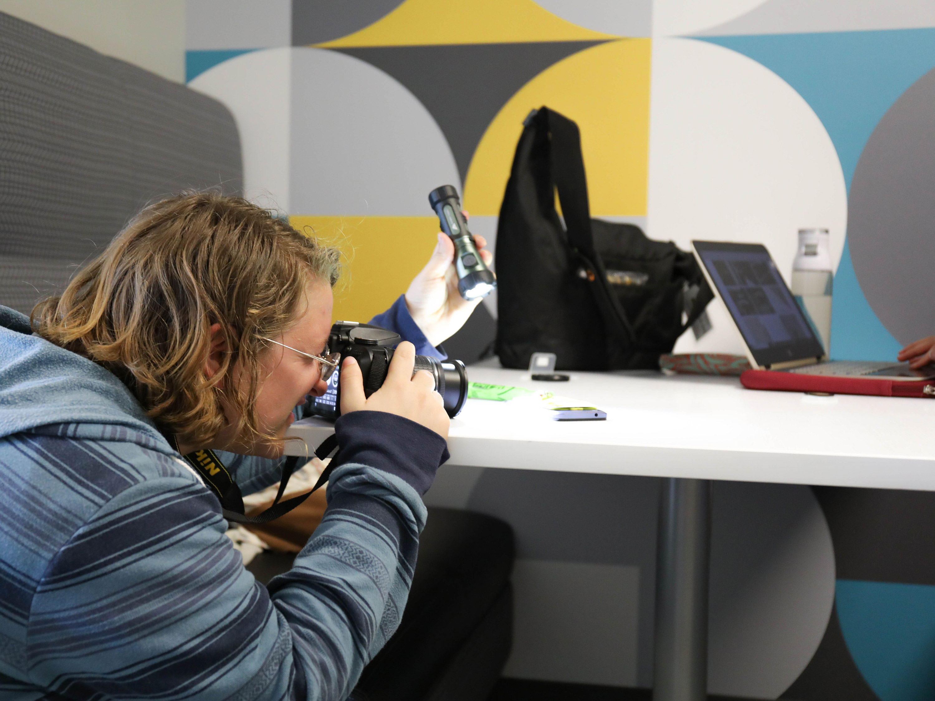 A student takes a photo on a digital camera.