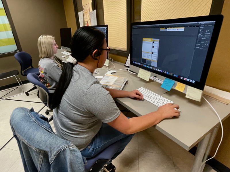 two people working on computers doing graphic design