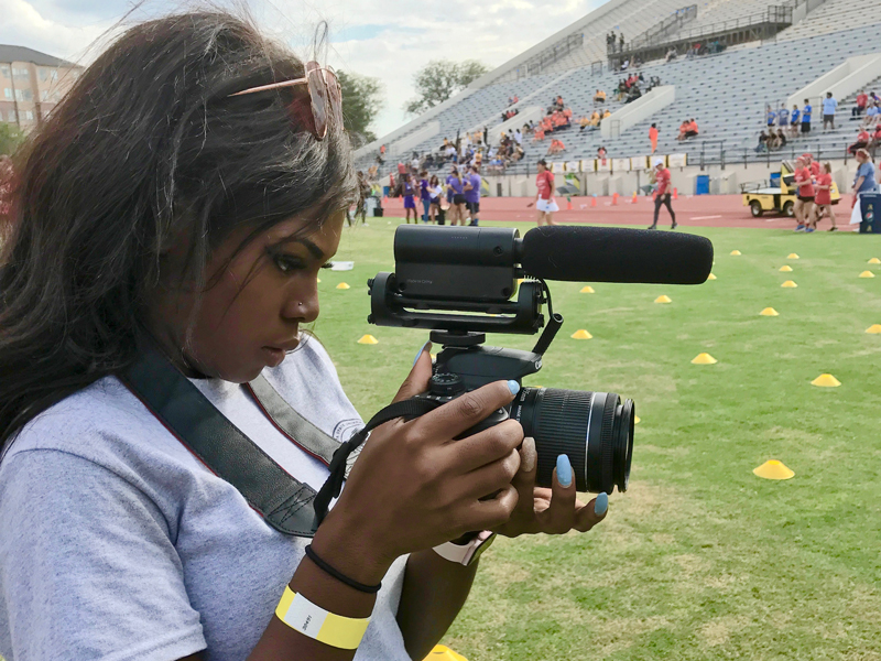 woman holds camera to video 