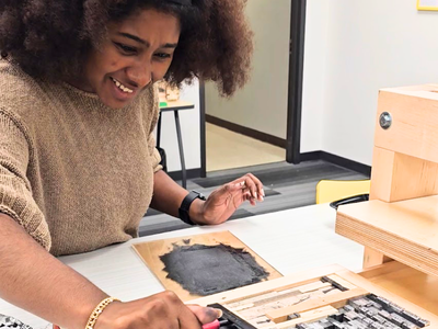 Zariah inks up type in the letterpress