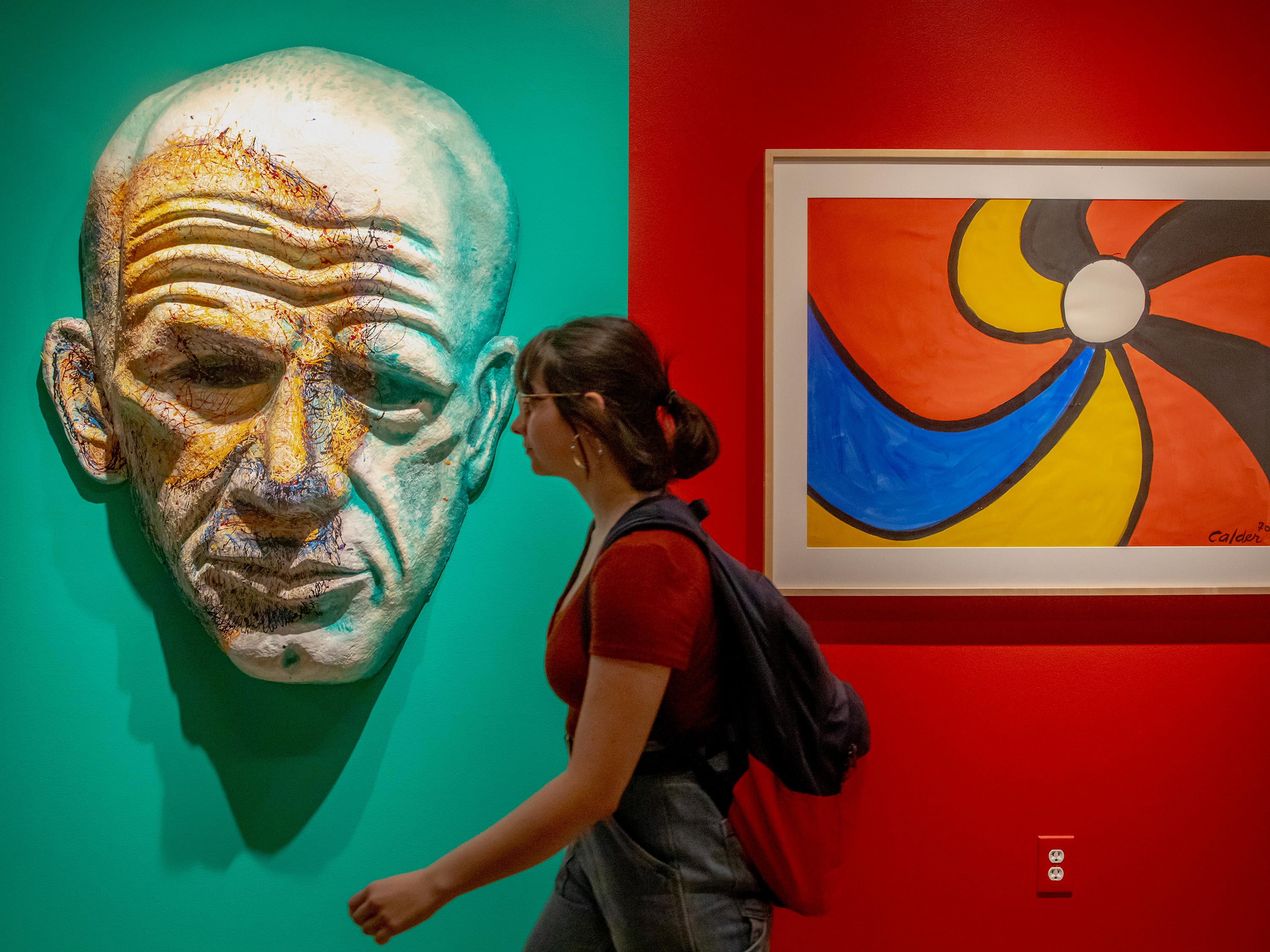 A student walks by artwork on display in the Ulrich Museum of Art