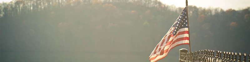 waving American flag on a lake dock